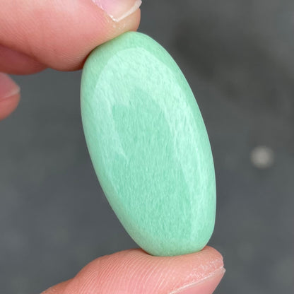A loose, oval cabochon cut variscite stone from Utah, USA.