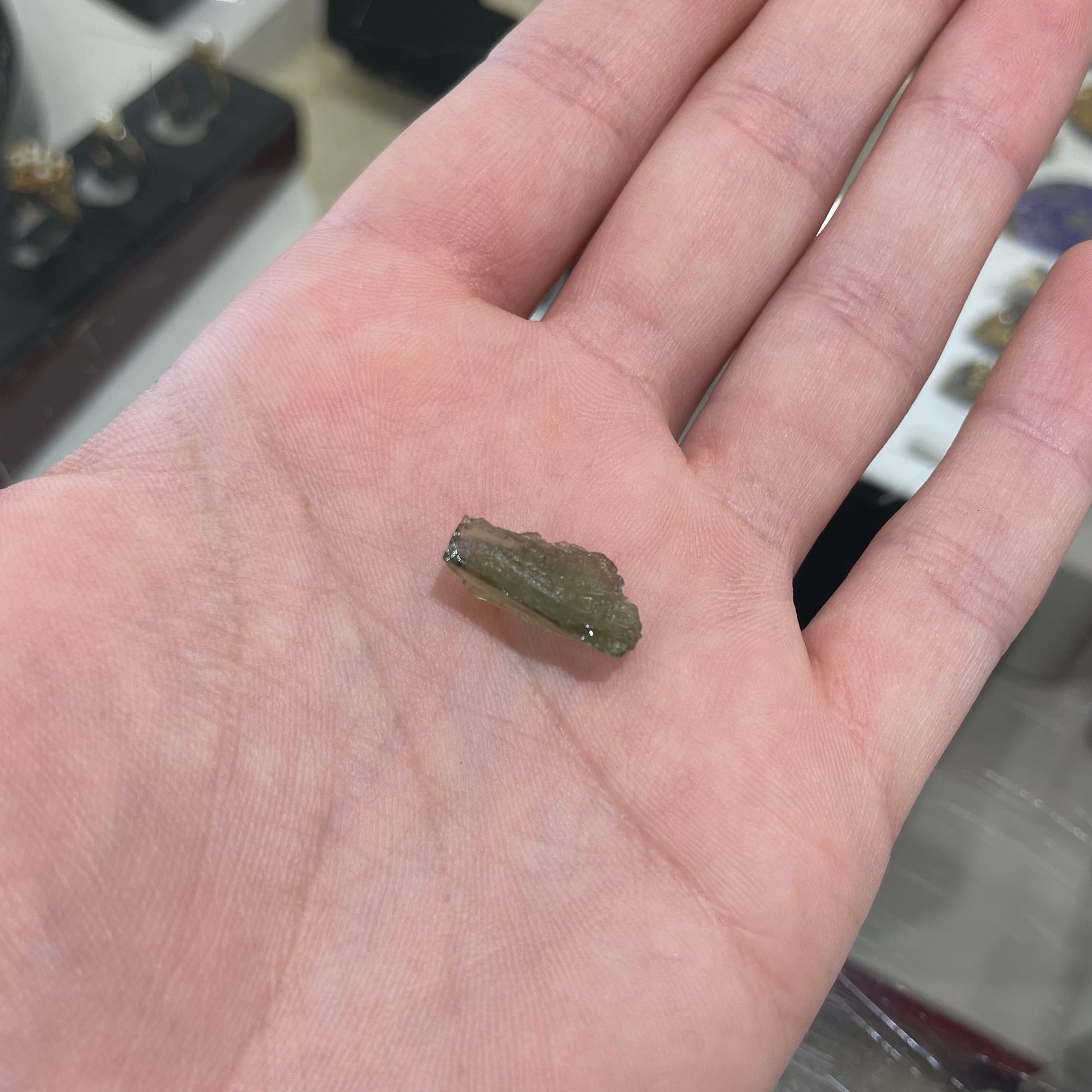 A loose, natural moldavite crystal.