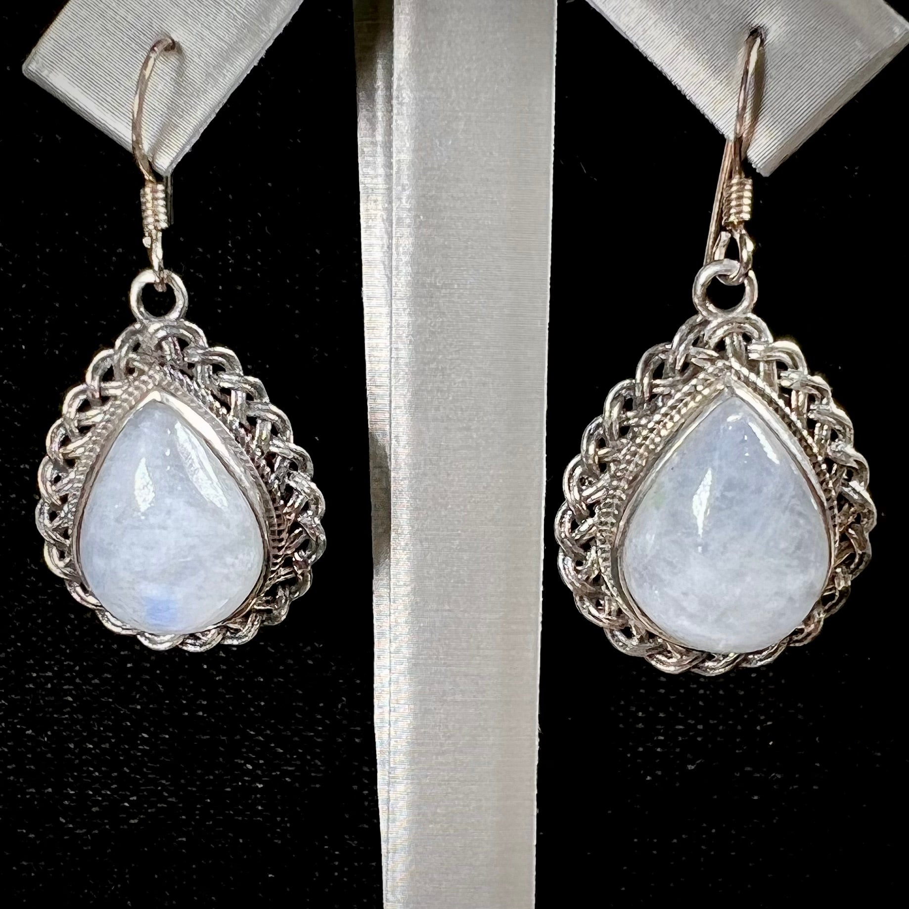Silver filigree dangle wire earrings set with pear shape moonstones.