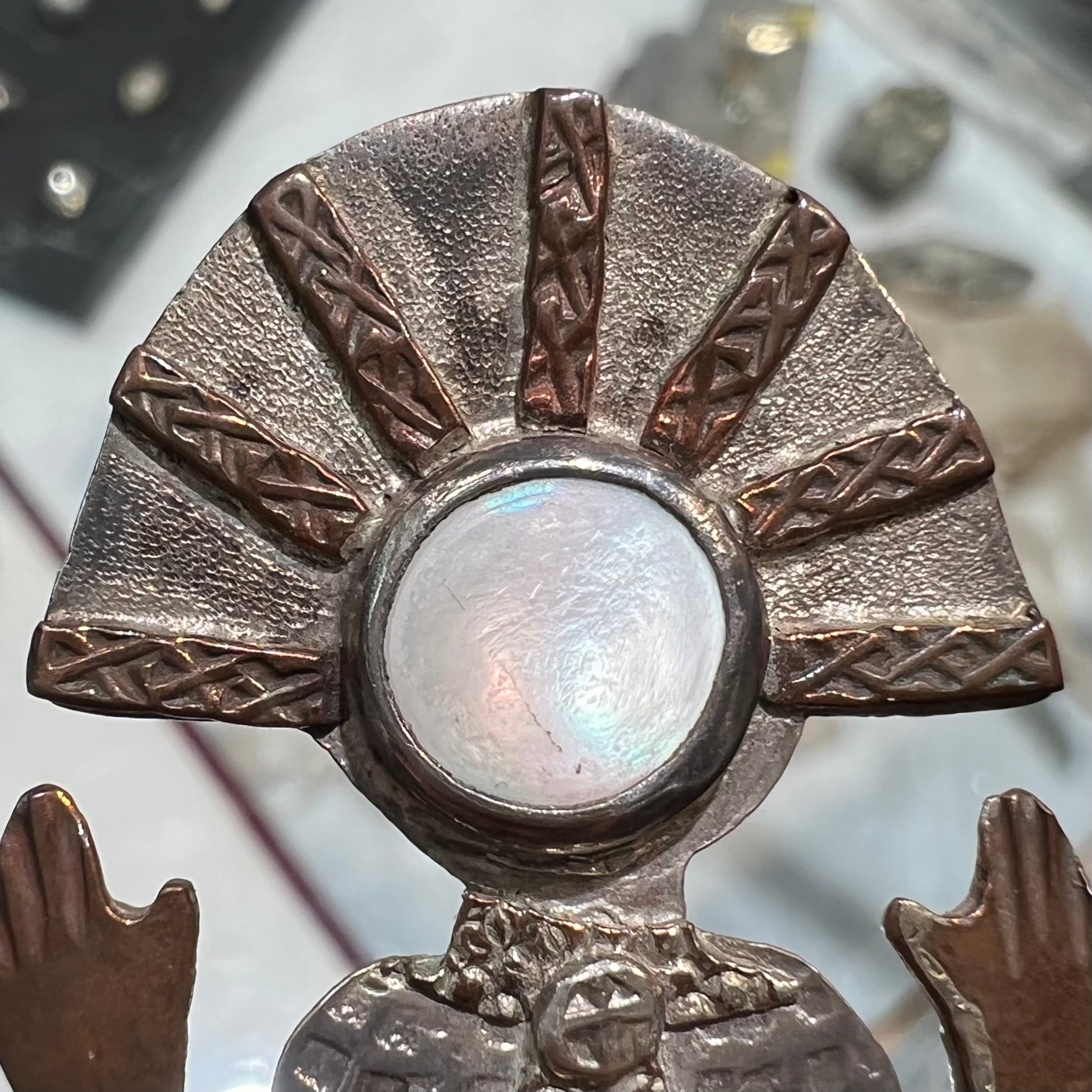 A handmade Navajo style silver pendant with copper highlights shaped like a Navajo Indian shaman.  There is a mother of pearl set as the shaman's face.