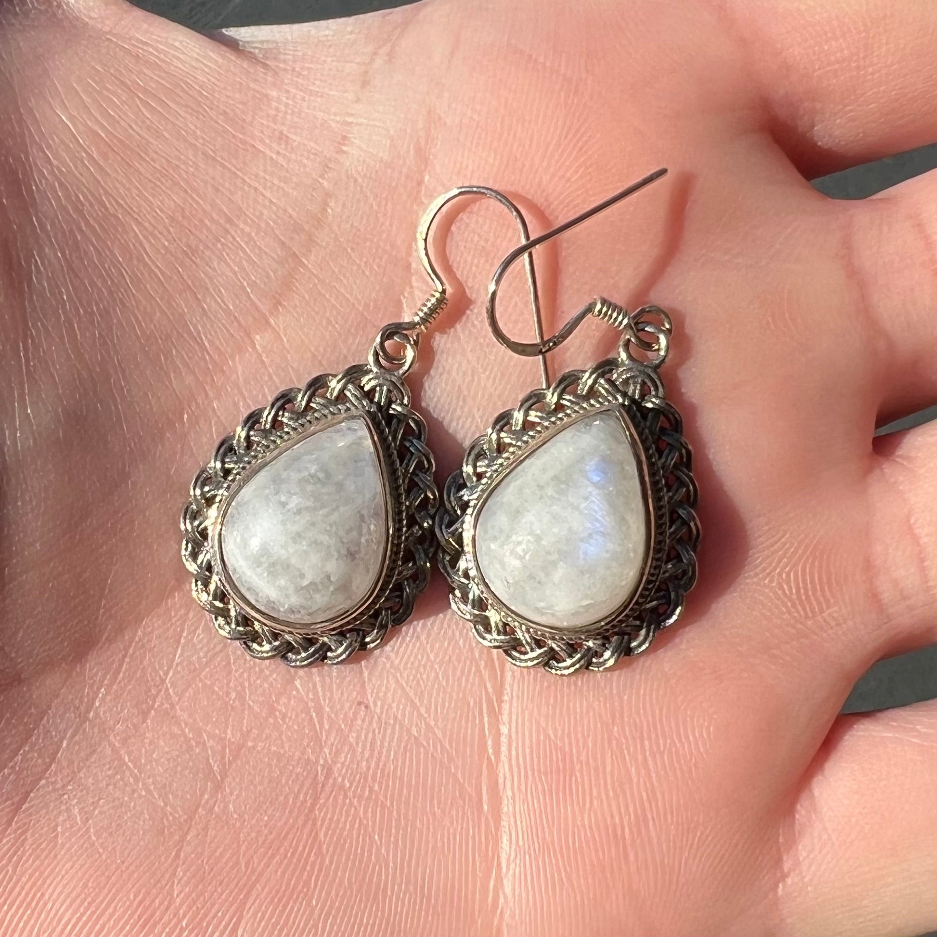 Silver filigree dangle wire earrings set with pear shape moonstones.