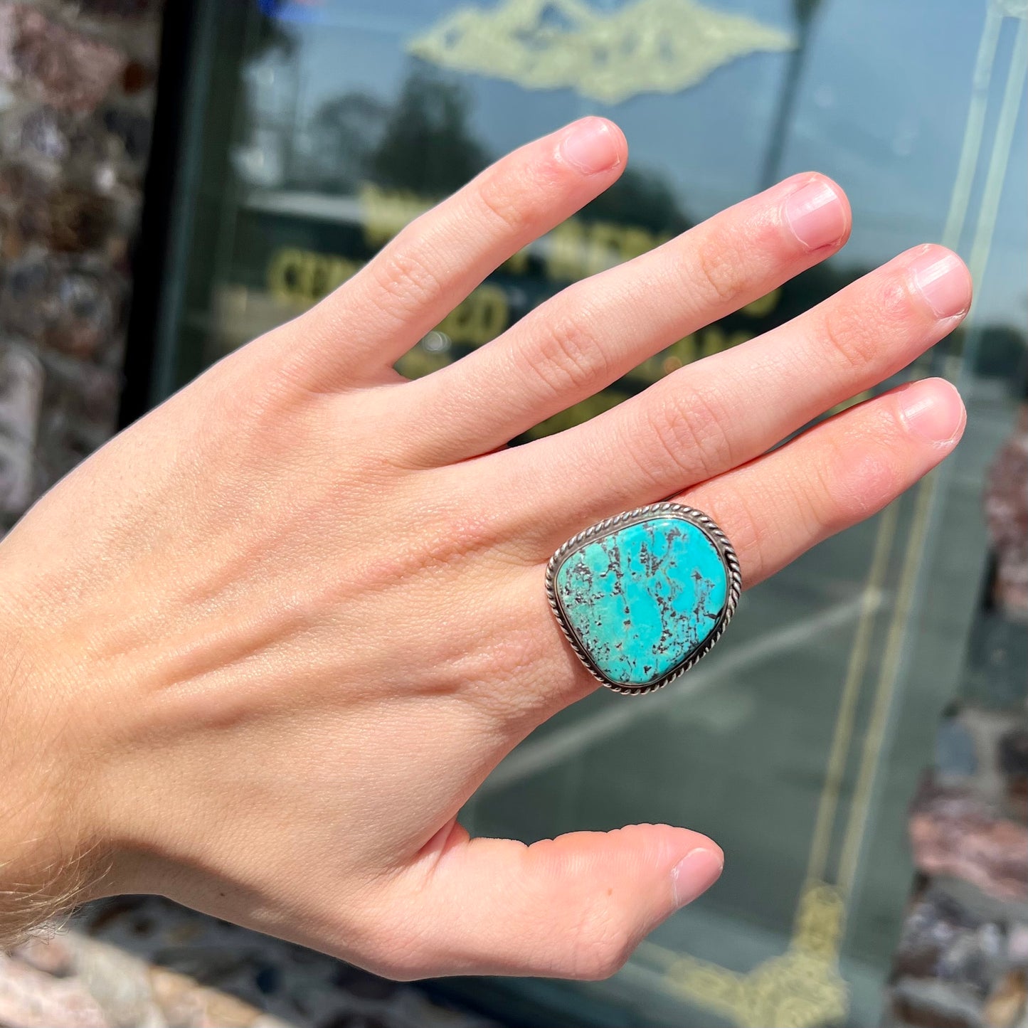 A men's sterling silver ring bezel set with a blue Morenci turquoise.  The ring is signed "SAM PIASO".