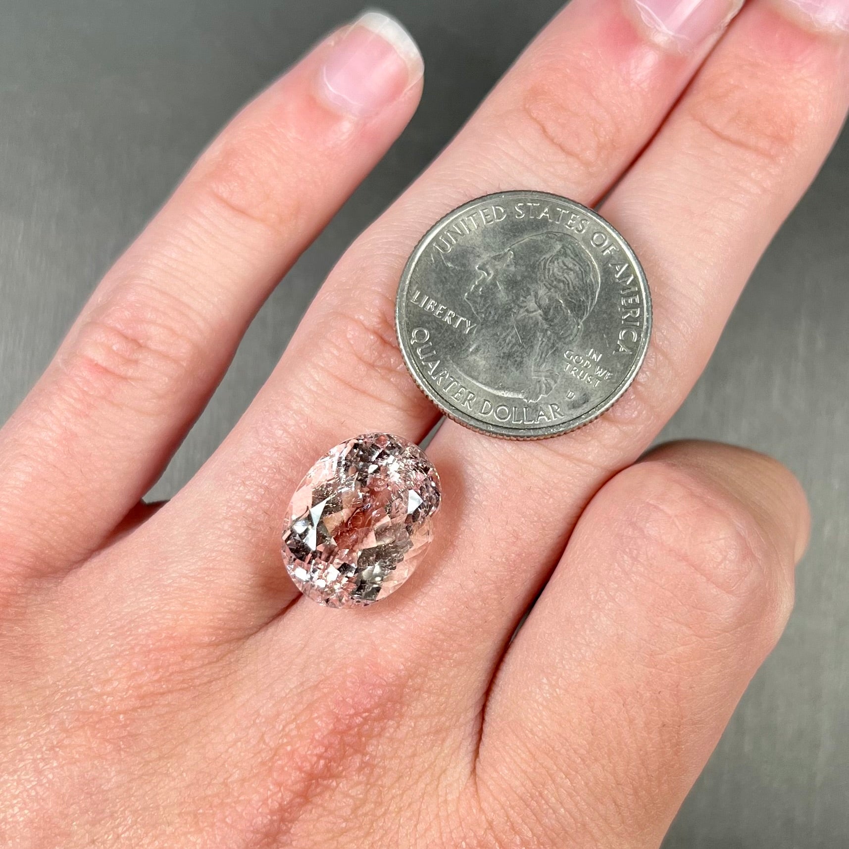 A loose, faceted oval cut pink morganite stone weighing over 14 carats.