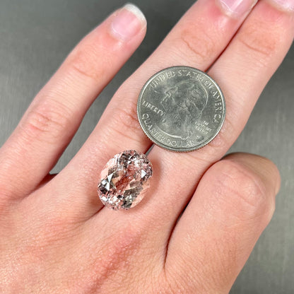 A loose, faceted oval cut pink morganite stone weighing over 14 carats.