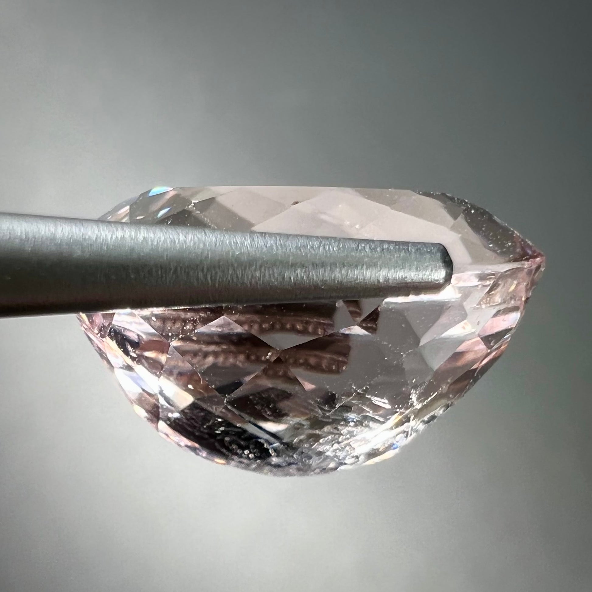 A loose, faceted oval cut pink morganite stone weighing over 14 carats.