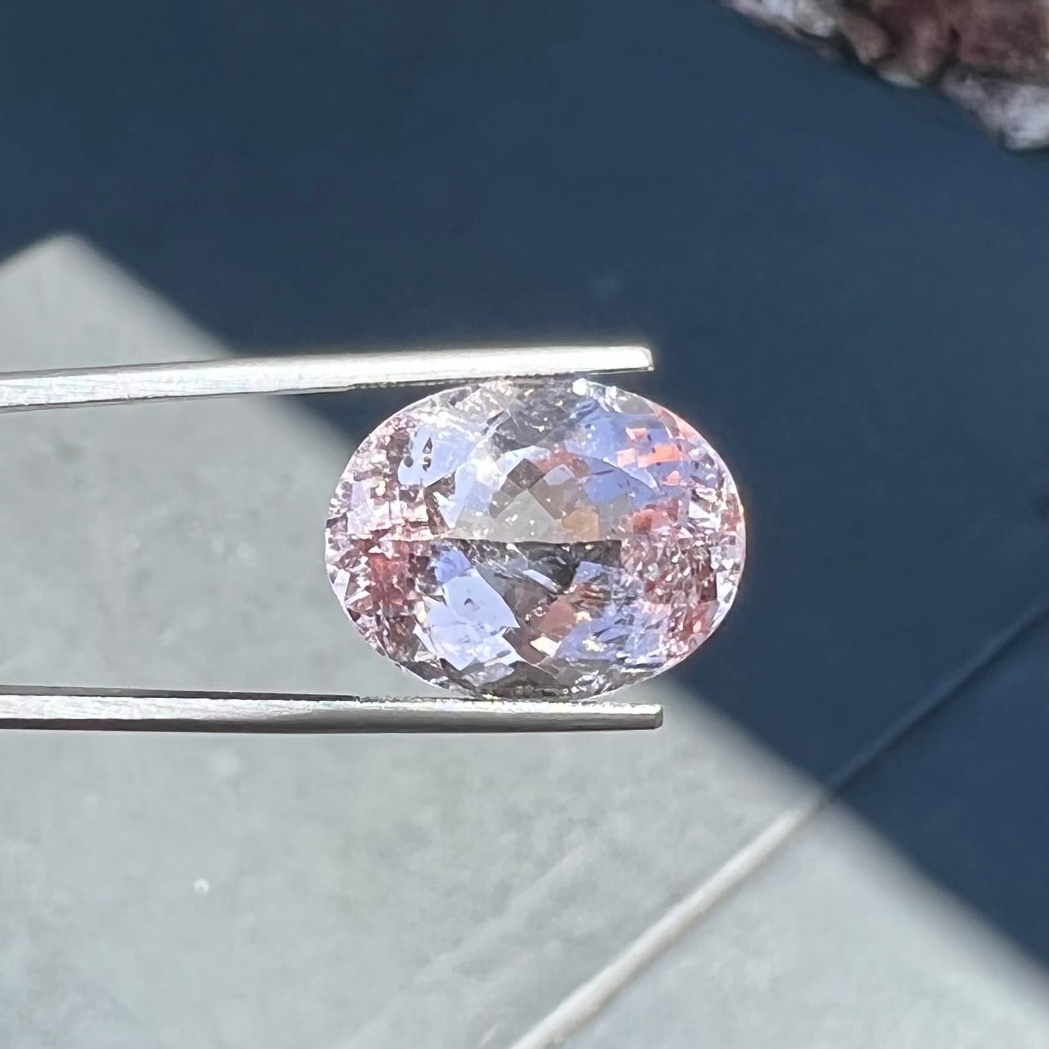 A loose, faceted oval cut pink morganite stone weighing over 14 carats.