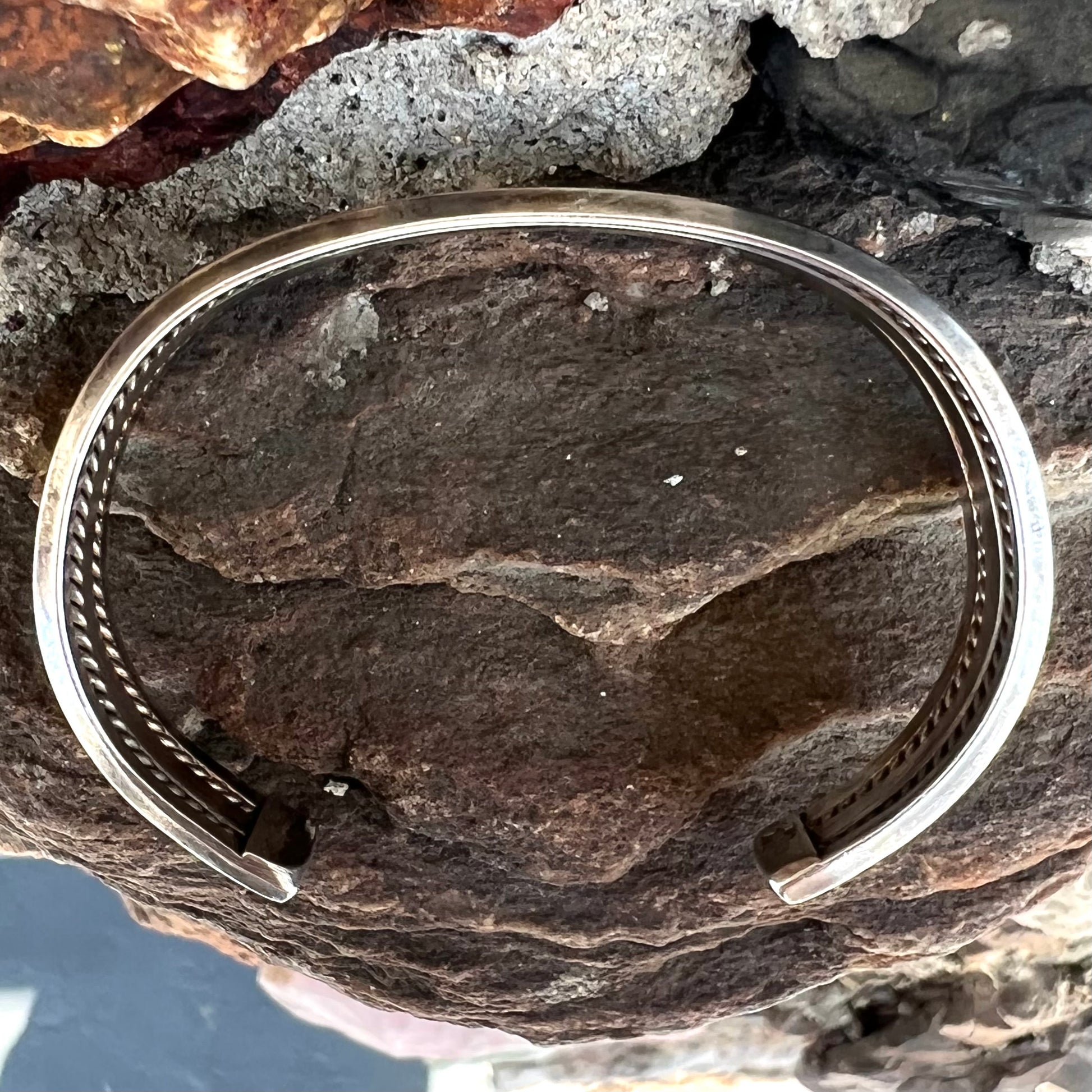 A handmade sterling silver cuff bracelet.  The bracelet is made with a rope wire.
