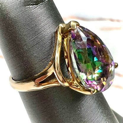 Pear shape green and pink mystic topaz set in a yellow gold ring with a single round diamond.
