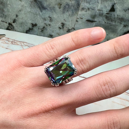 Emerald cut mystic topaz prong set in a decorative sterling silver ring.
