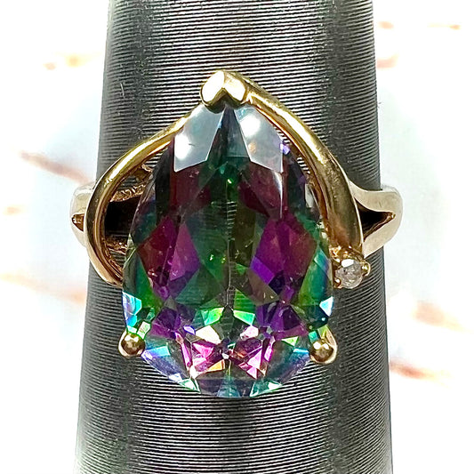 Pear shape green and pink mystic topaz set in a yellow gold ring with a single round diamond.