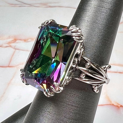 Emerald cut mystic topaz prong set in a decorative sterling silver ring.