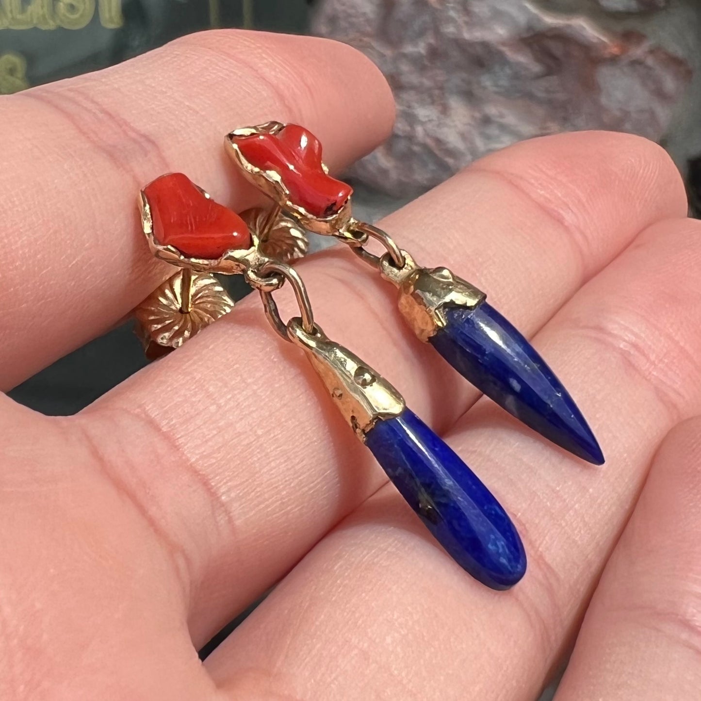 A pair of Navajo-handmade yellow gold dangle earrings set with lapis lazuli and polished coral branches.