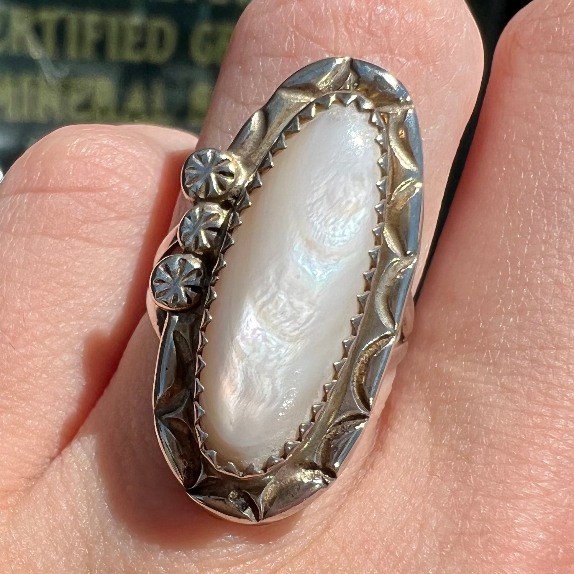 A Southwest style silver ring set with a faint pink mother of pearl stone.