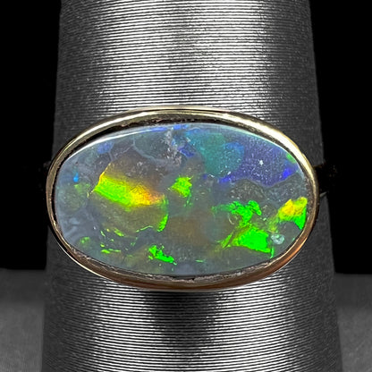 A ladies' yellow gold black opal solitaire ring from Lightning Ridge, Australia.
