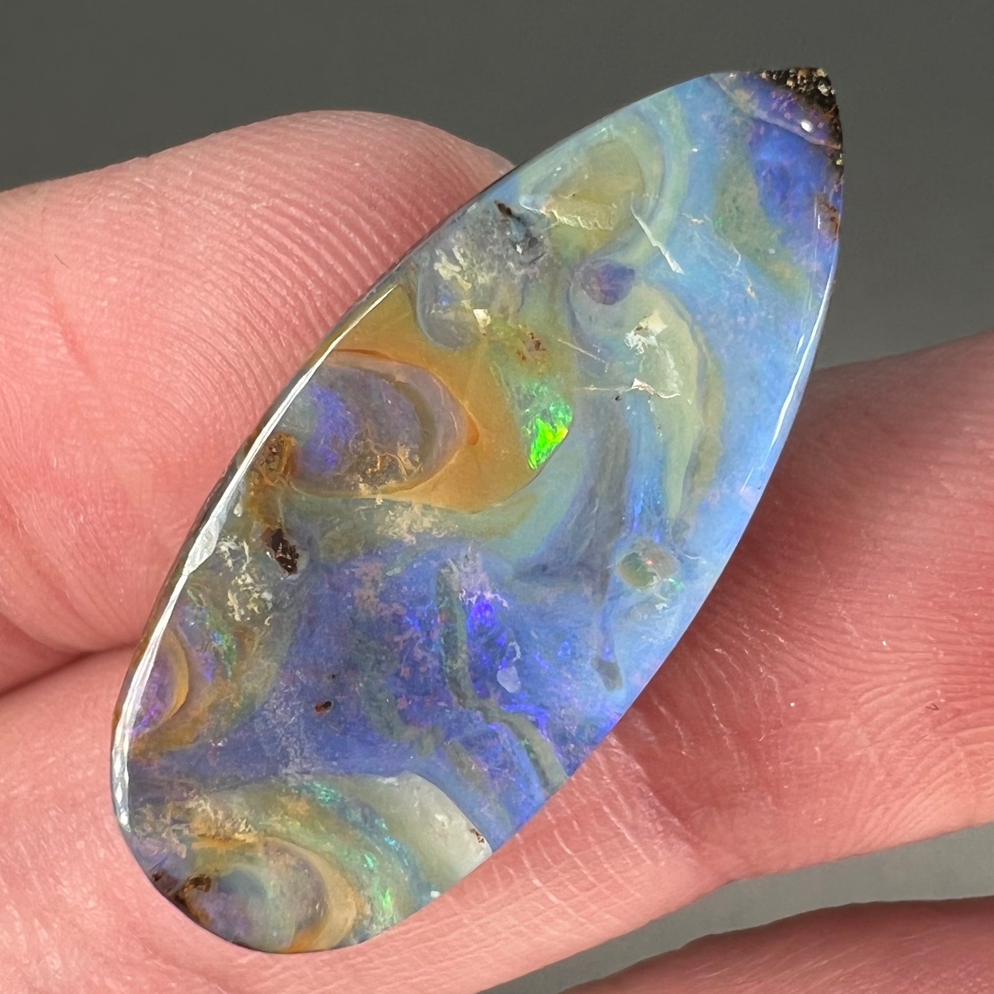 A loose, natural, pear shaped boulder opal stone from Quilpie, Australia.