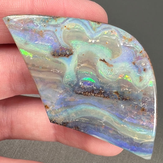 A polished boulder opal stone from Queensland, Australia.