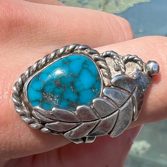 A handmade Navajo men's turquoise ring.  The ring is made with wire and carved silver.