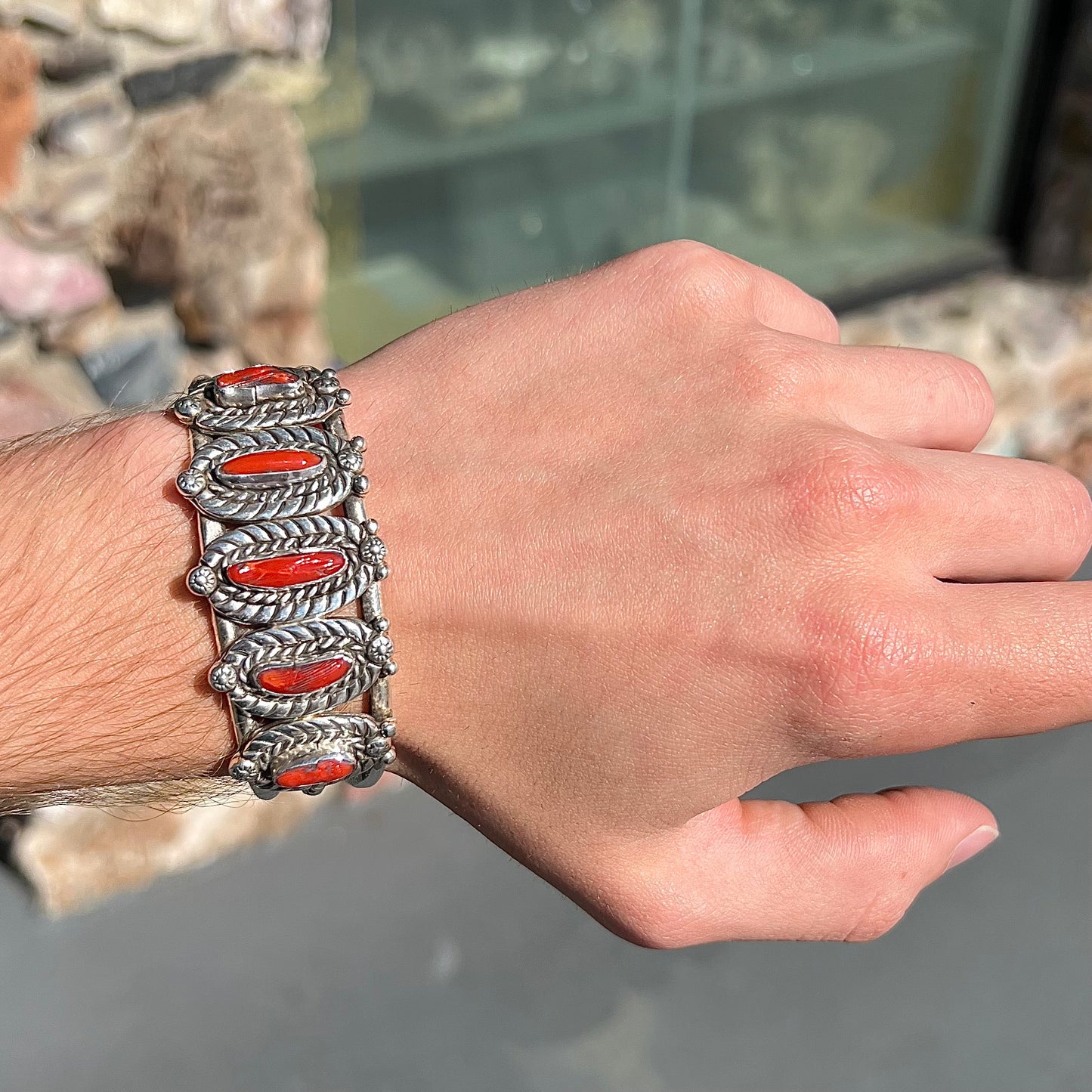 A sterling silver cuff bracelet set with polished coral branches handmade by Navajo artist, Delbert Chatter.