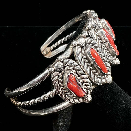 A sterling silver cuff bracelet set with polished coral branches handmade by Navajo artist, Delbert Chatter.