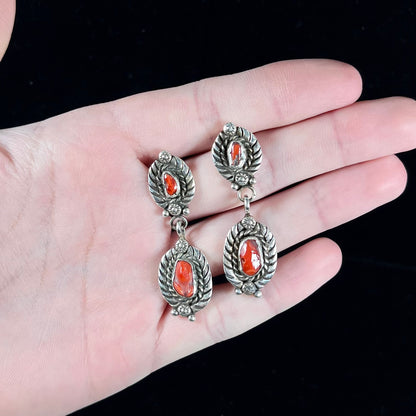 A pair of vintage coral branch dangle earrings handmade by Navajo artist, Delbert Chatter.