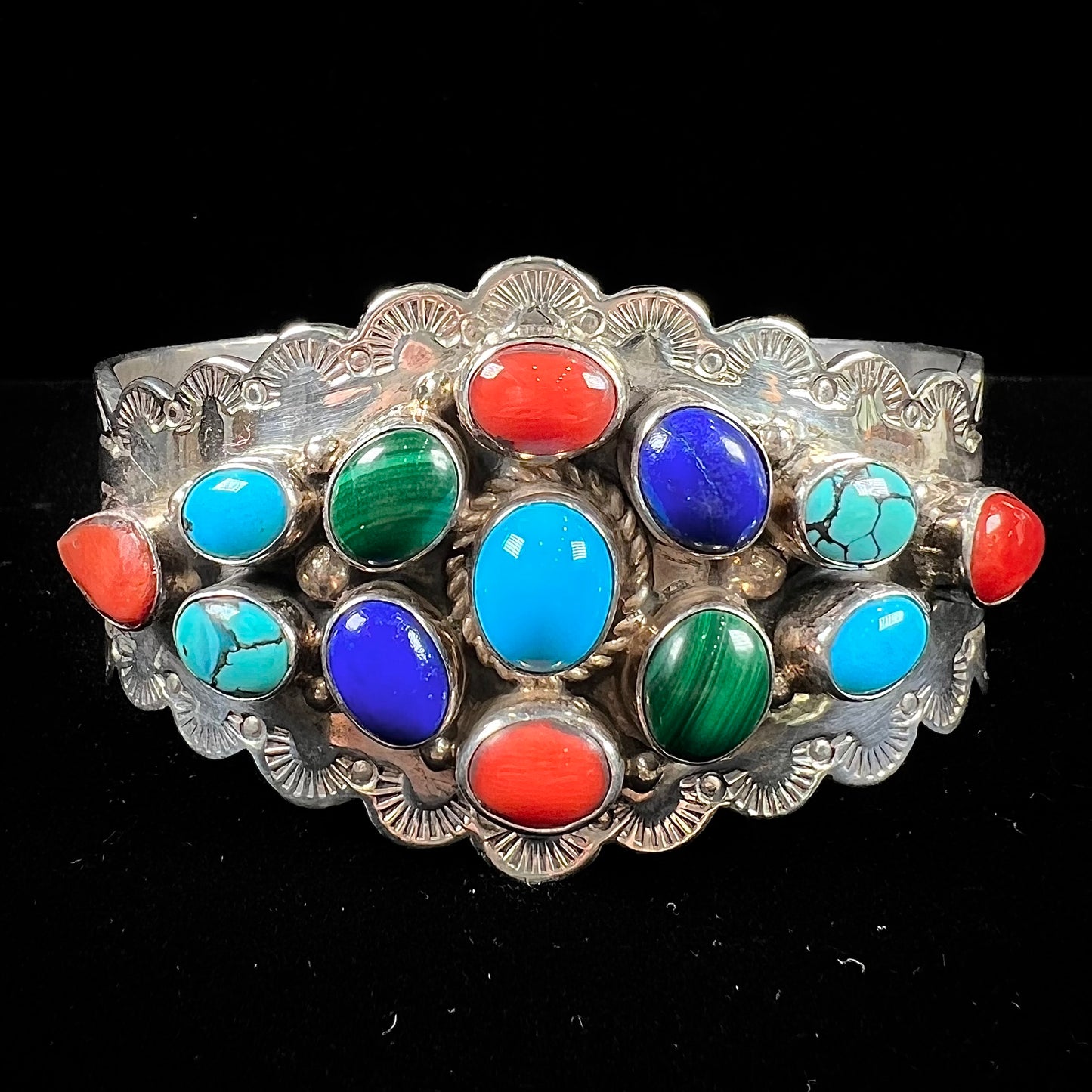 A sterling silver ladies' Navajo cuff bracelet set with turquoise, malachite, lapis lazuli, and coral stones.