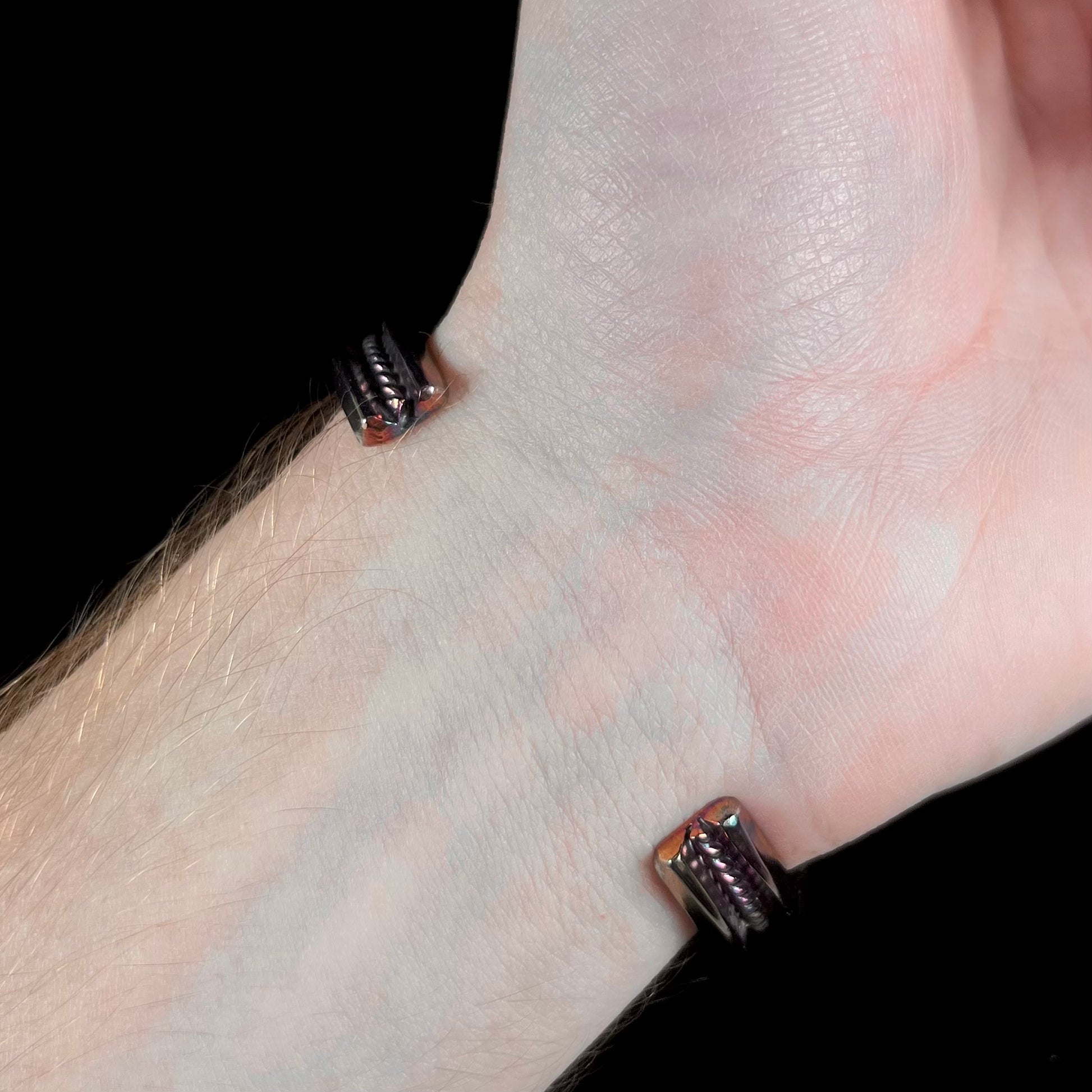 A men's Navajo three stone turquoise cuff bracelet handmade by artist, Dean Brown.  The silver has an iridescent purple patina.
