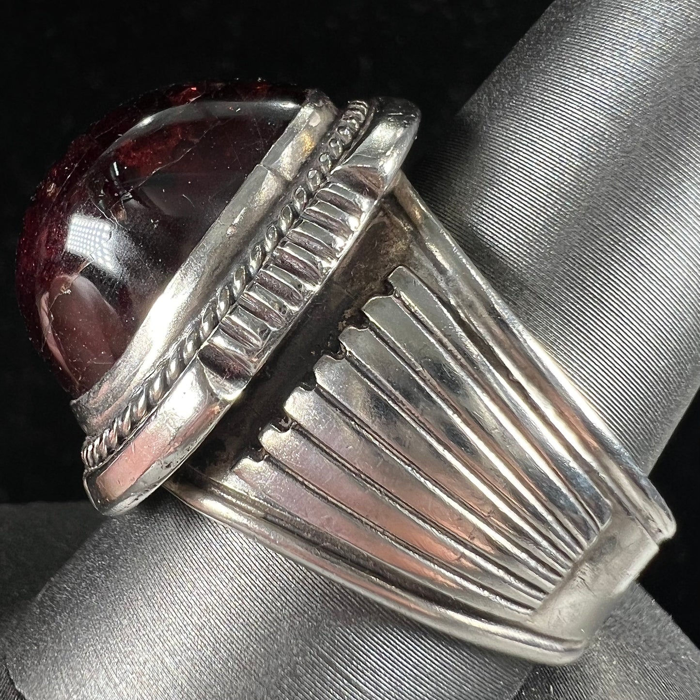 A men's sterling silver garnet ring handmade by Navajo artist Will Denetdale.