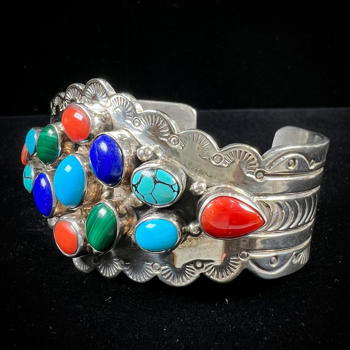 A sterling silver ladies' Navajo cuff bracelet set with turquoise, malachite, lapis lazuli, and coral stones.