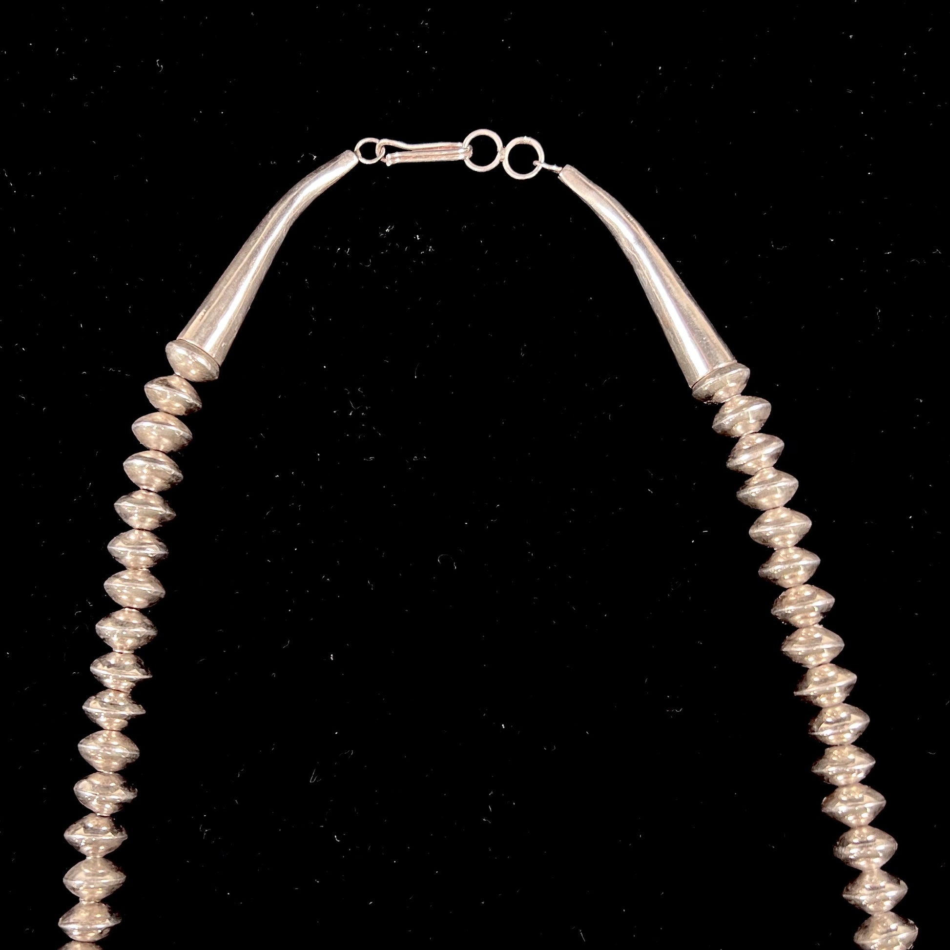 A Navajo style squash blossom necklace set with red coral branches, handmade by artist Delbert Chatter.