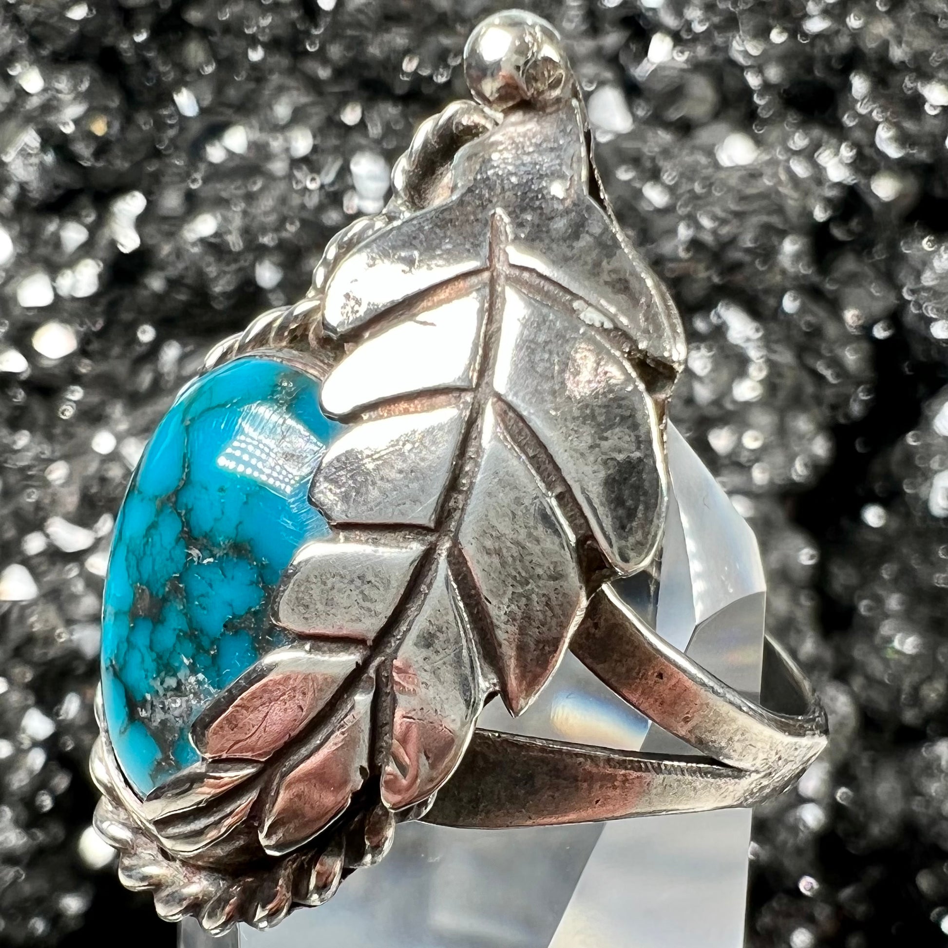 A handmade Navajo men's turquoise ring.  The ring is made with wire and carved silver.