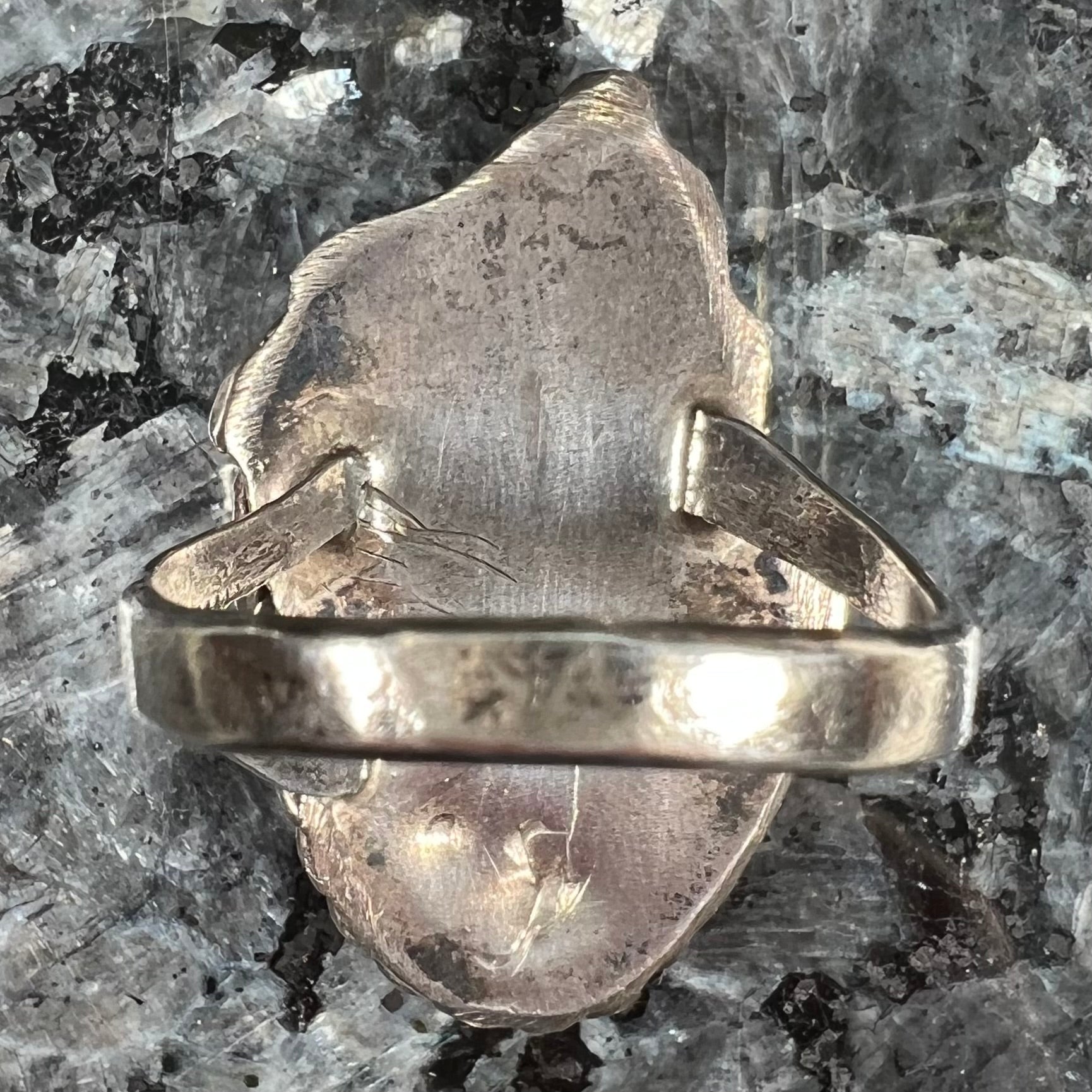 A handmade Navajo men's turquoise ring.  The ring is made with wire and carved silver.