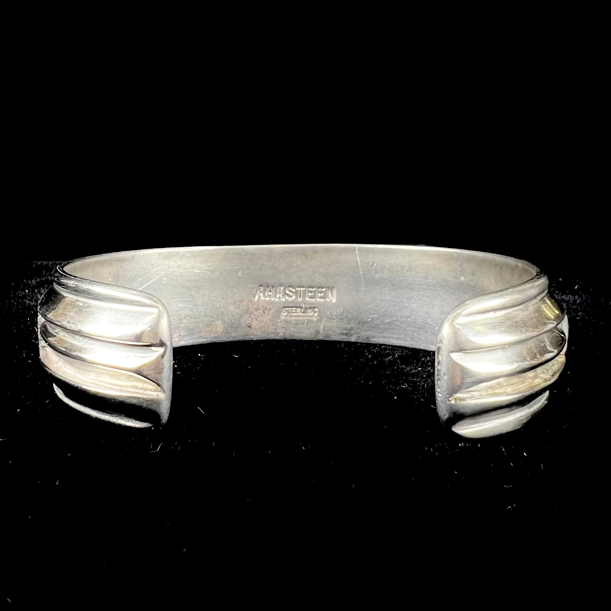 A vintage sterling silver stone inlay cuff bracelet, signed "AHASTEEN" by the Navajo artsit.