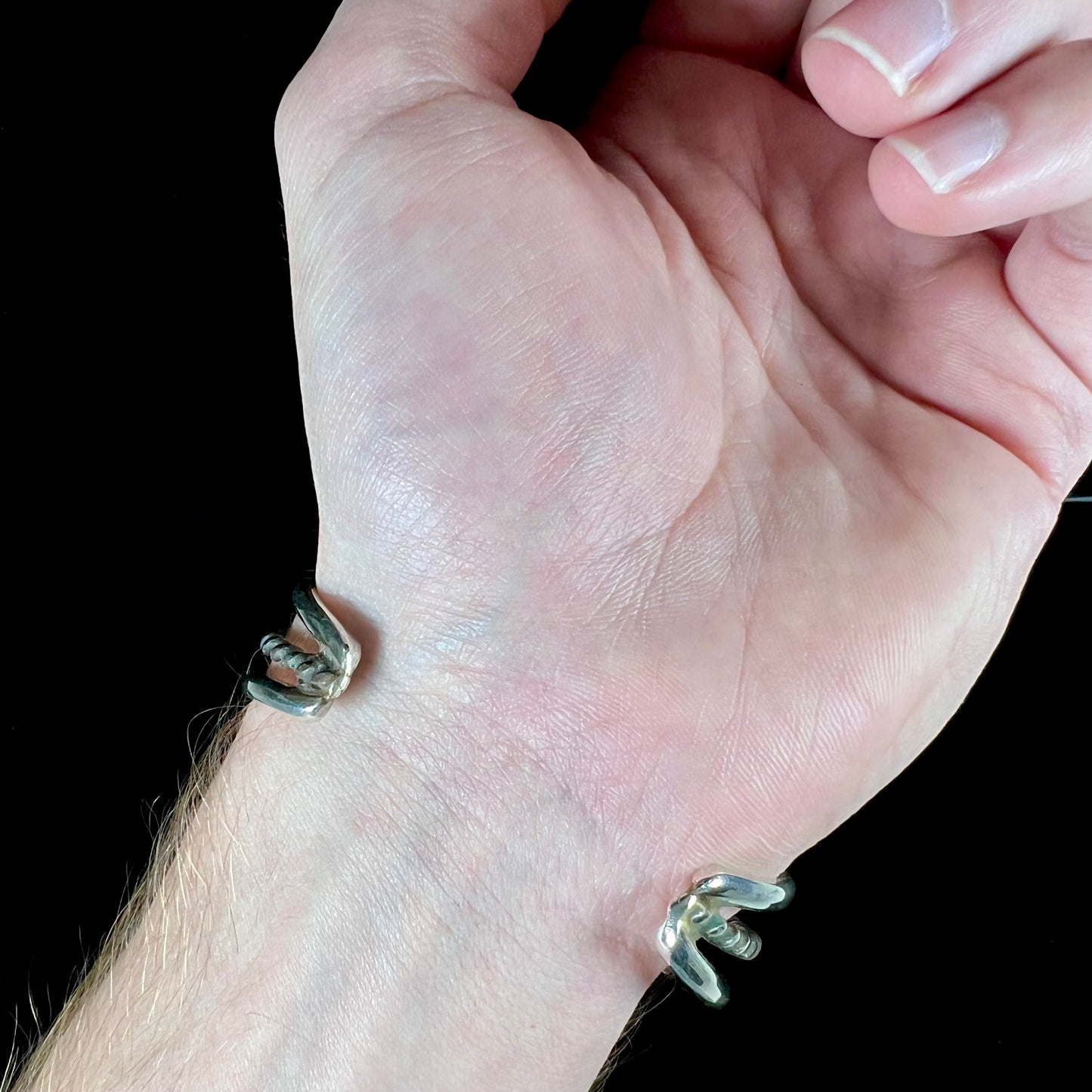 A sterling silver cuff bracelet set with polished coral branches handmade by Navajo artist, Delbert Chatter.