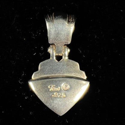 A Navajo-made pendant inlaid with tiger's eye and synthetic opal stones.