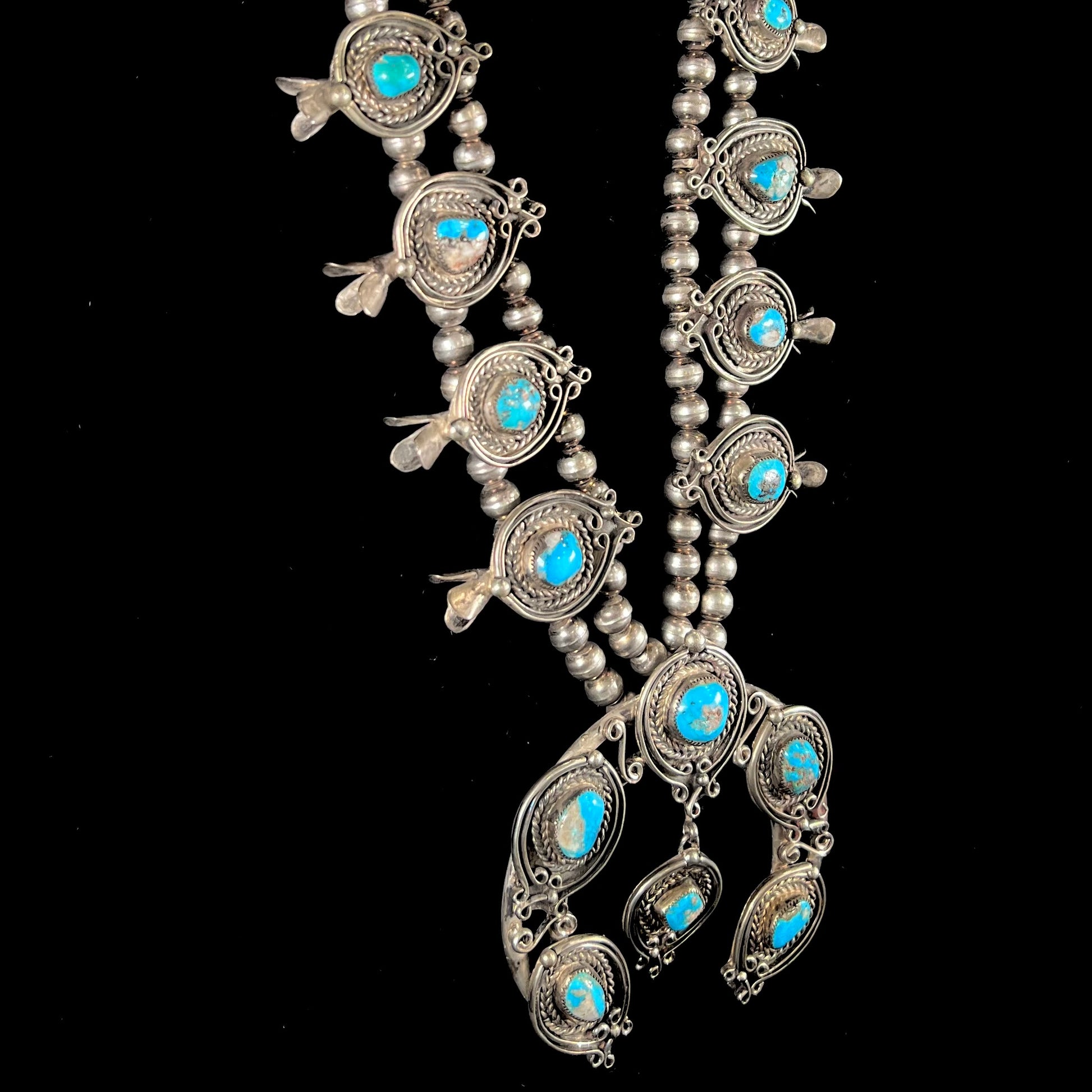 A men's Navajo silver squash blossom necklace set with Kingman turquoise stones.