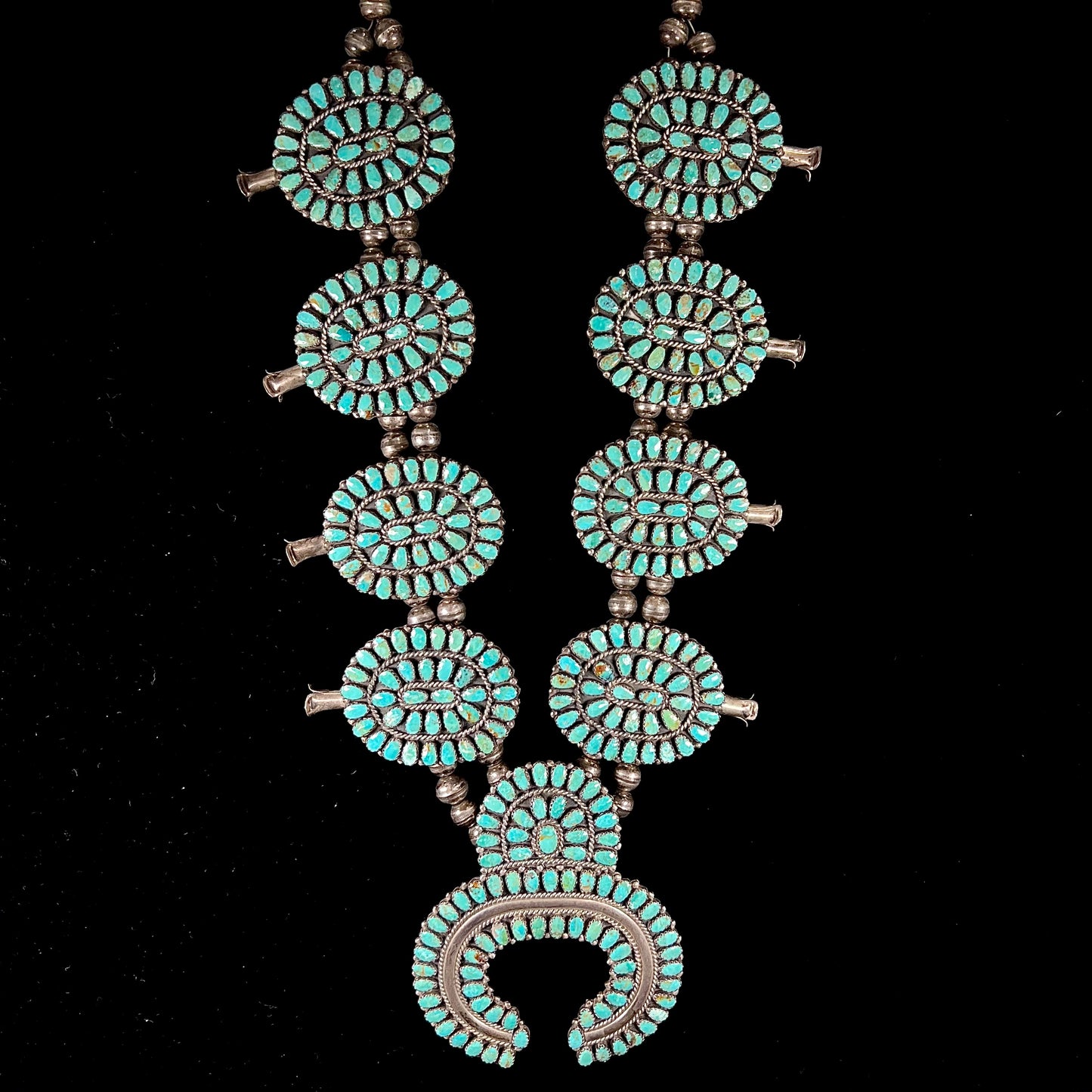 A Native American silver squash blossom turquoise petit point set with turquoise by Larry Moses Begay.