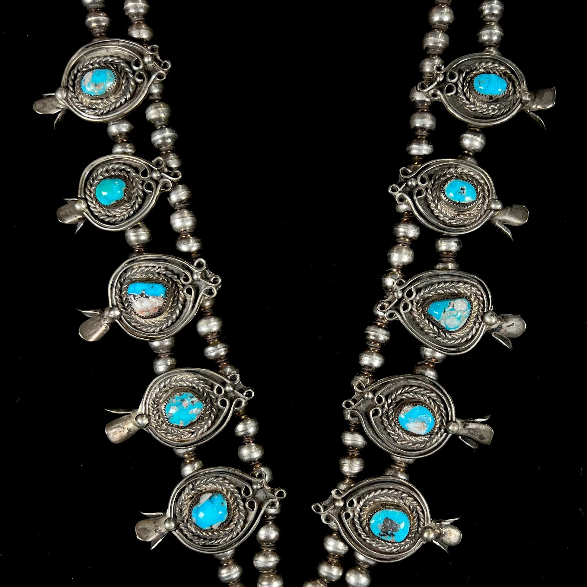 A men's Navajo silver squash blossom necklace set with Kingman turquoise stones.