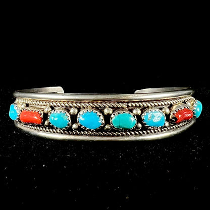 A silver ladies' turquoise and coral cuff bracelet, handmade by Navajo artist, John Delvin.