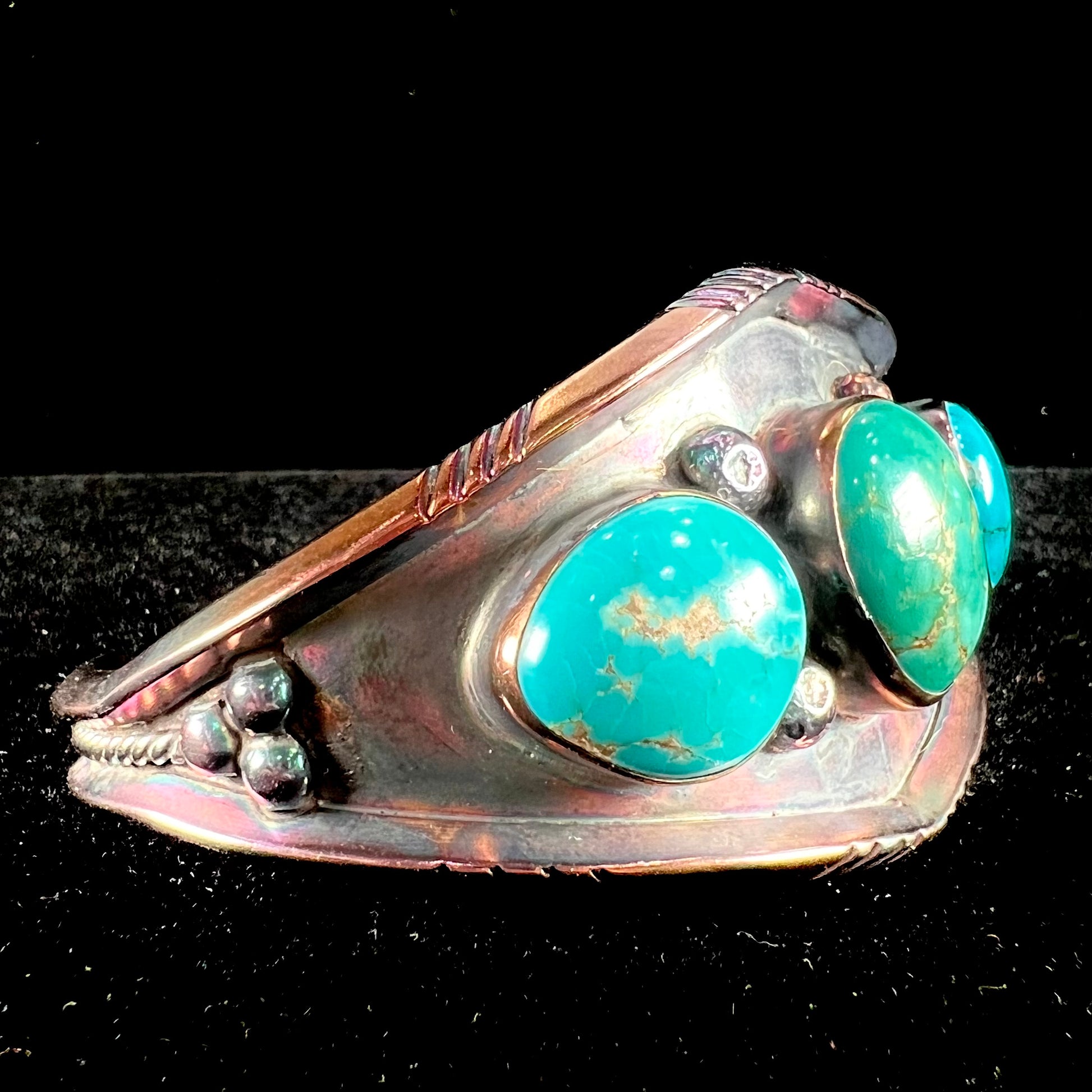 A men's Navajo three stone turquoise cuff bracelet handmade by artist, Dean Brown.  The silver has an iridescent purple patina.