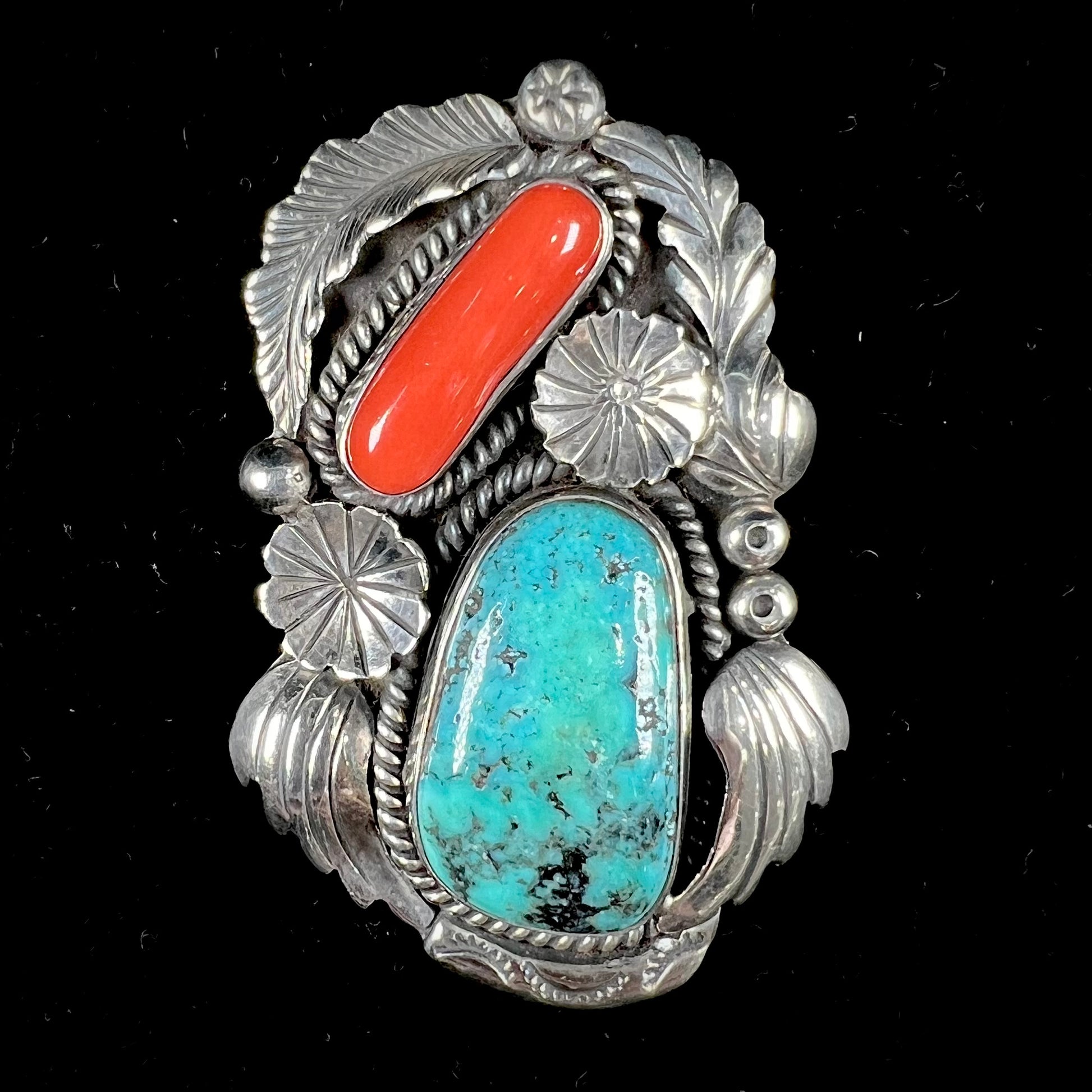 A sterling silver, 1970's Navajo pendant set with Kingman turquoise and coral stones, handmade by artist Angela Lee.