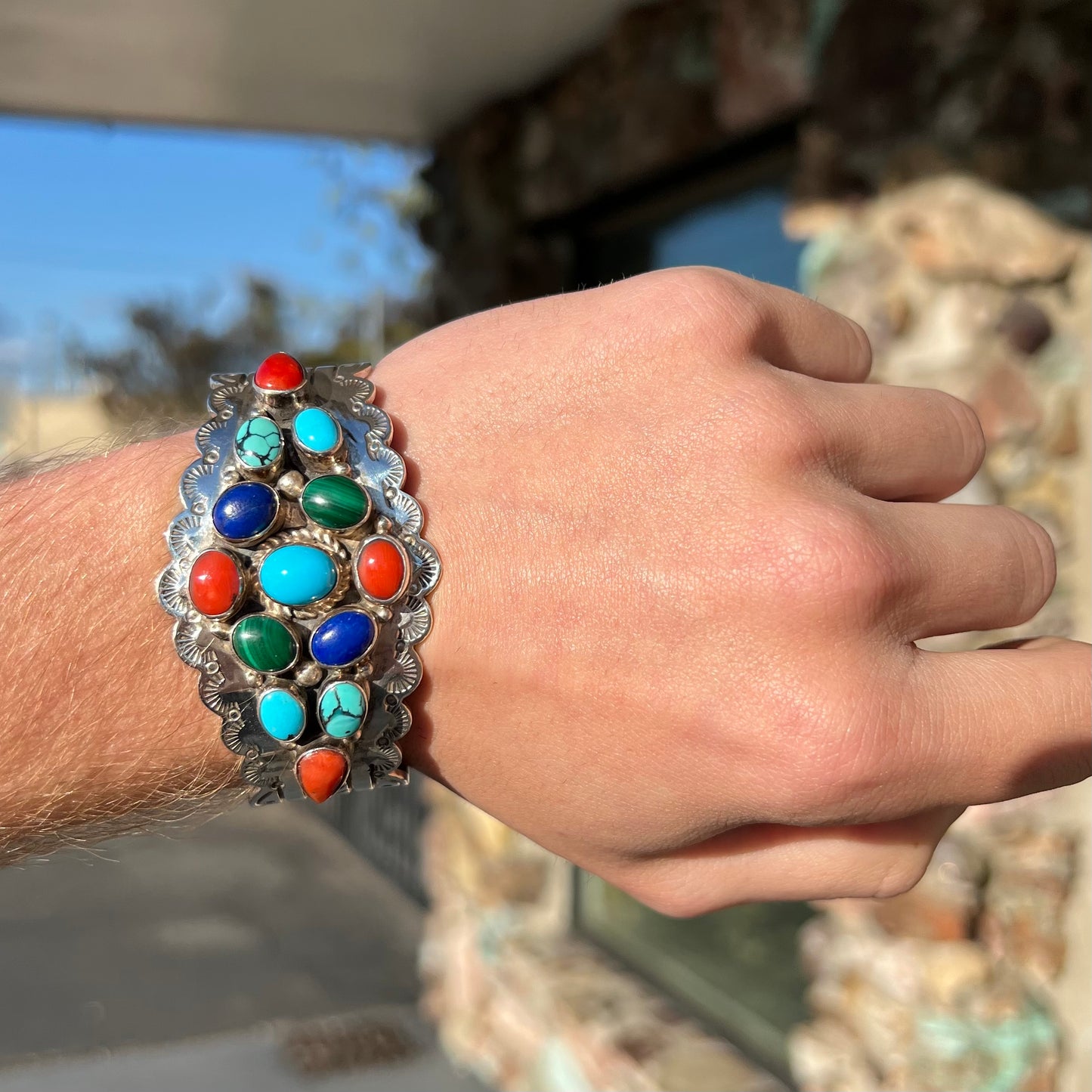A sterling silver ladies' Navajo cuff bracelet set with turquoise, malachite, lapis lazuli, and coral stones.