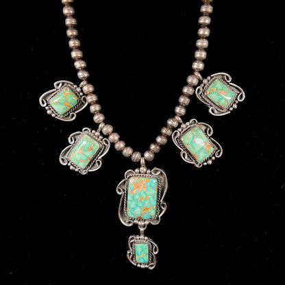 A sterling silver Navajo turquoise necklace set with Pilot Mountain Mine turquoise stones by artist Minnie Thomas.