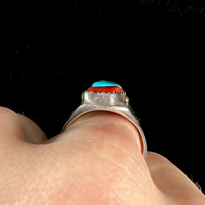 A men's sterling silver Navajo ring set with turquoise and red coral stones.