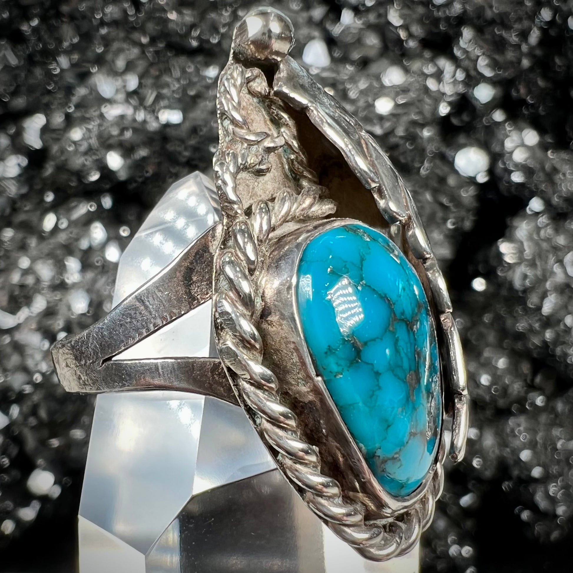 A handmade Navajo men's turquoise ring.  The ring is made with wire and carved silver.