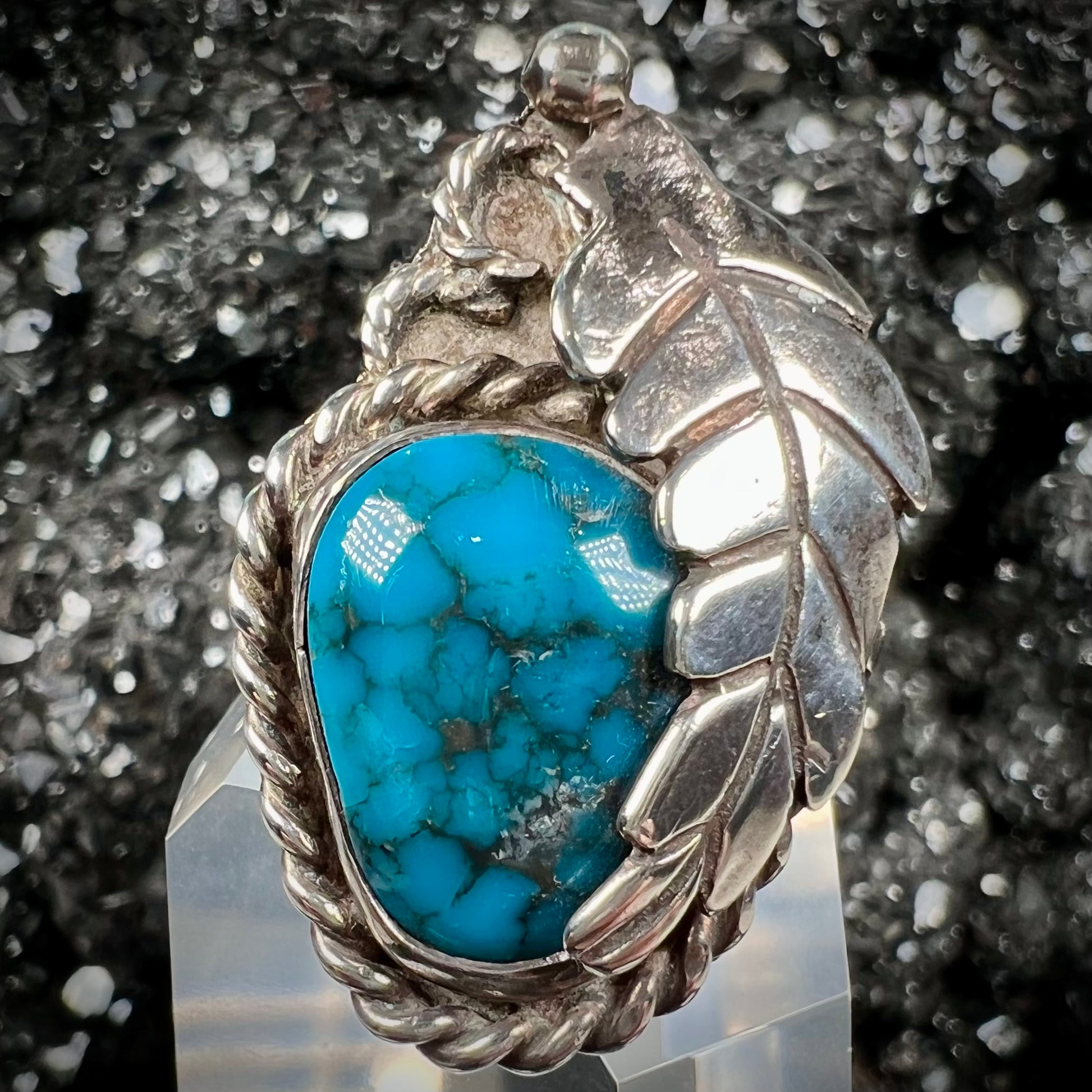 A handmade Navajo men's turquoise ring.  The ring is made with wire and carved silver.