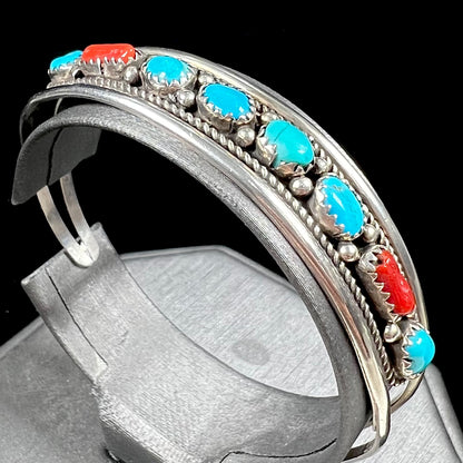 A silver ladies' turquoise and coral cuff bracelet, handmade by Navajo artist, John Delvin.