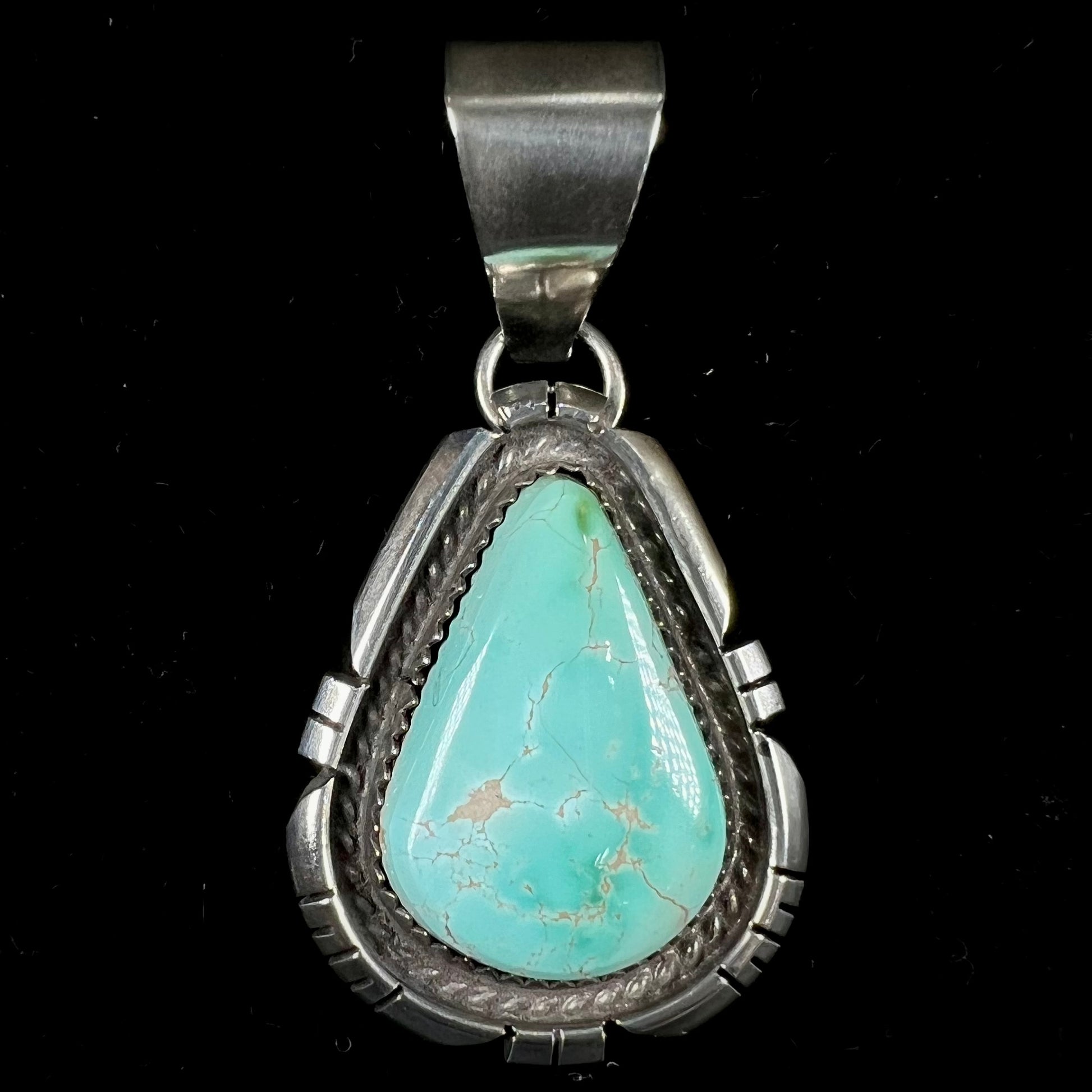 A sterling silver bezel set variscite stone pendant handmade by Navajo artist, Herman Lee.