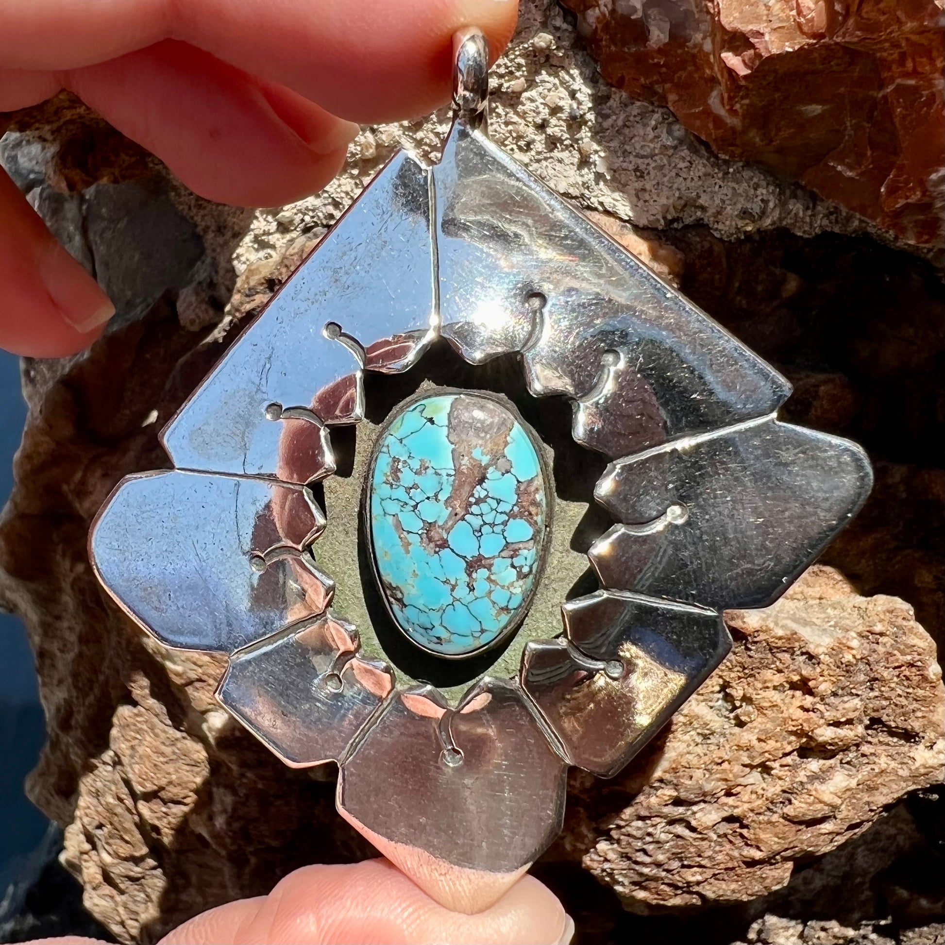 A handmade Mayan Indian pendant set with an oval cut turquoise stone from the Number 8 Mine.