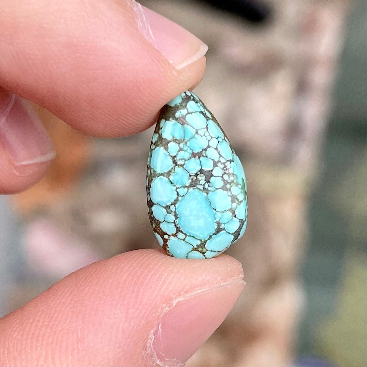 A loose, drop shaped turquoise stone from Number 8 Mine, Nevada.