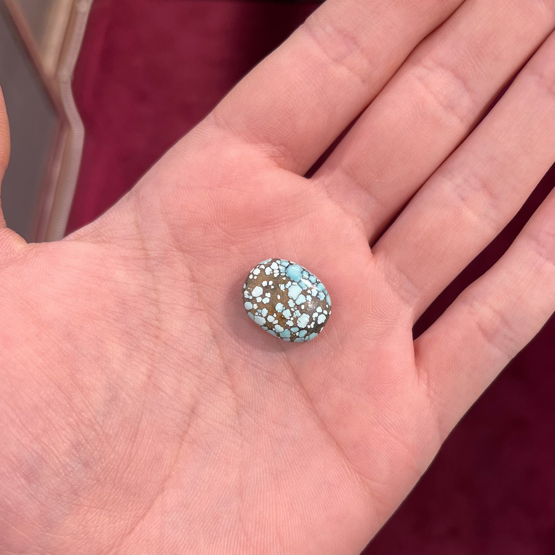 A light blue spiderweb turquoise stone with a greenish brown matrix from Number 8 Mine in Lander County, Nevada.